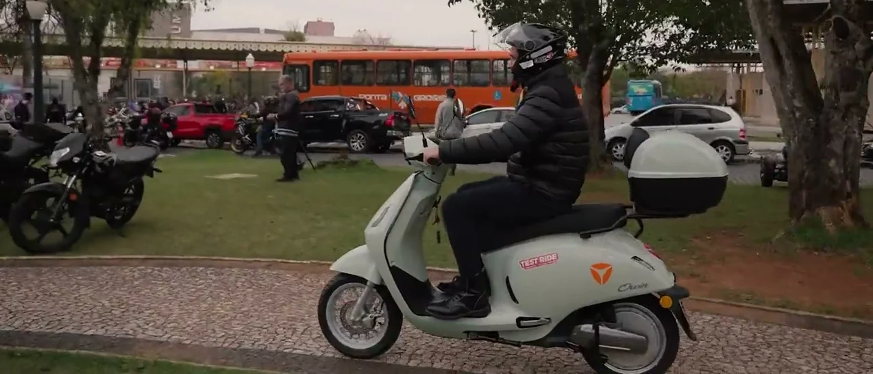Pessoa de capacete pilotando uma scooter elétrica Yadea em test ride